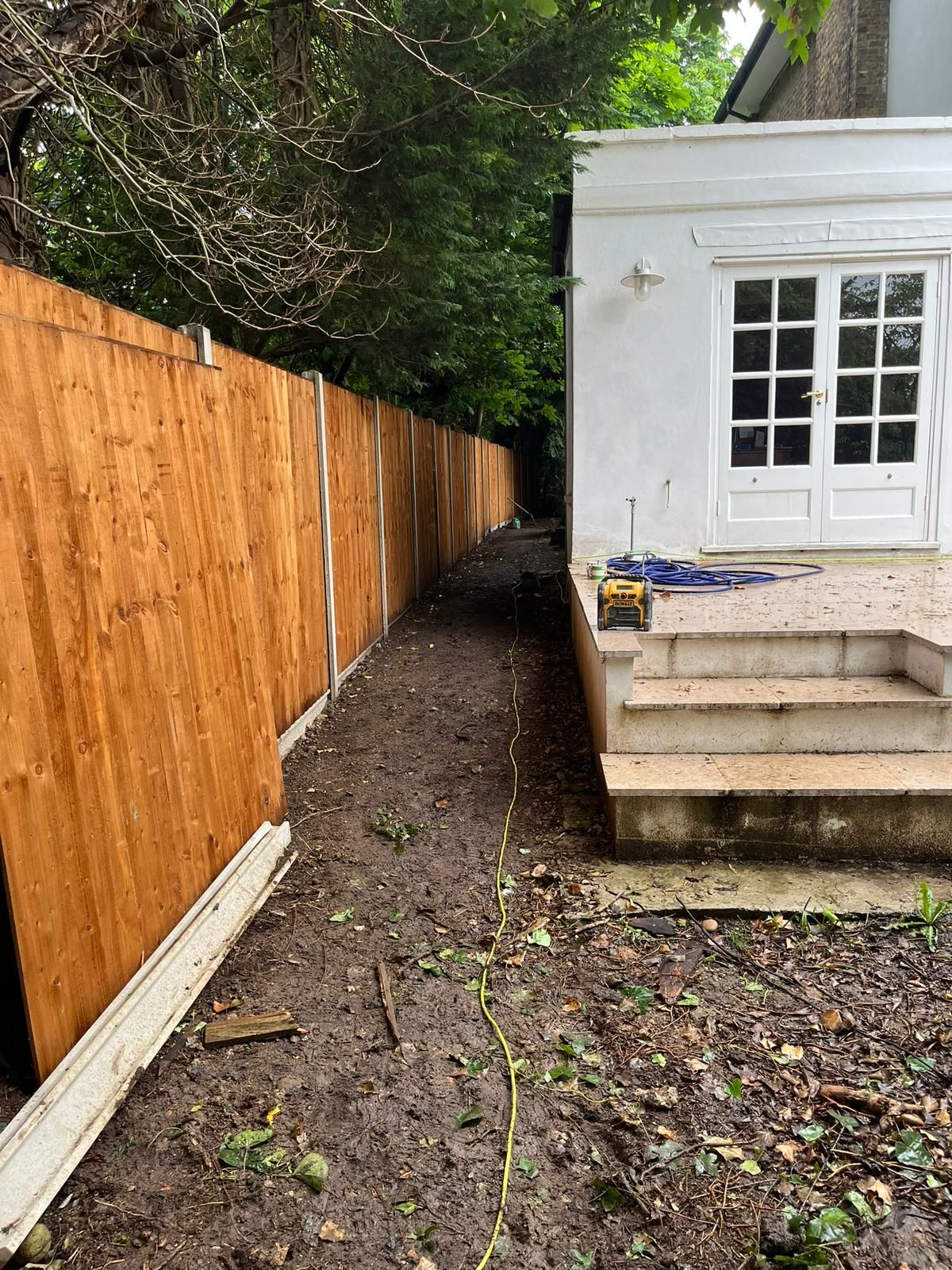 New closeboard fence line beside a side garden and stone steps