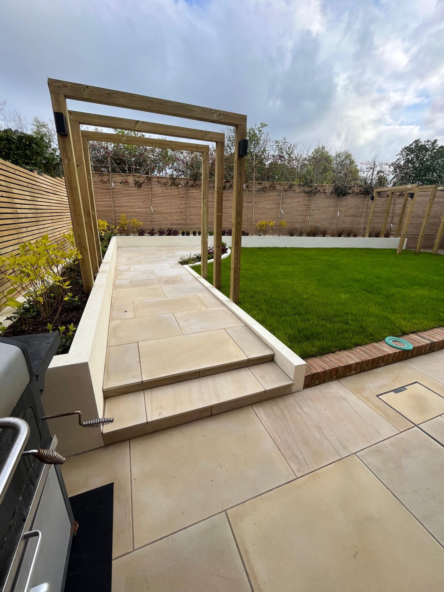 Hawk Landscapes sandstone patio with steps, pergola and new lawn