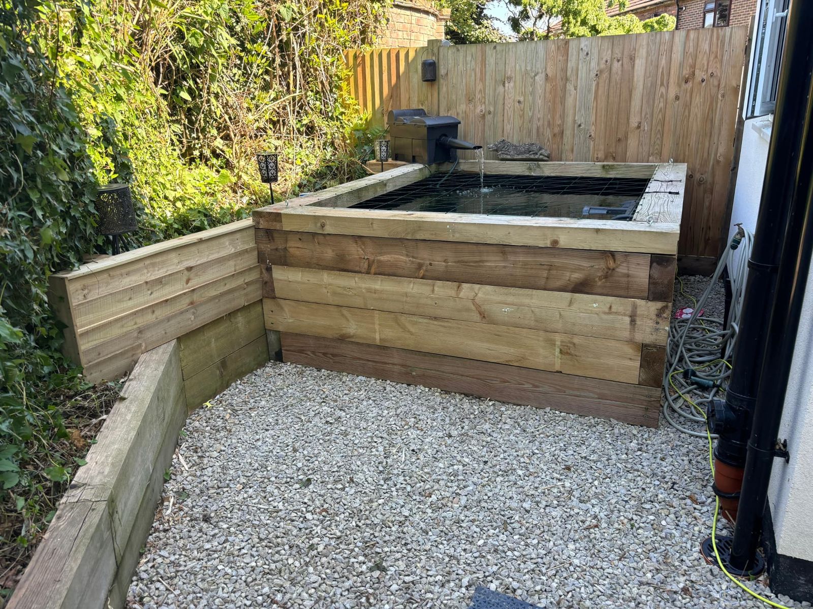 Raised timber sleeper pond with gravel surround